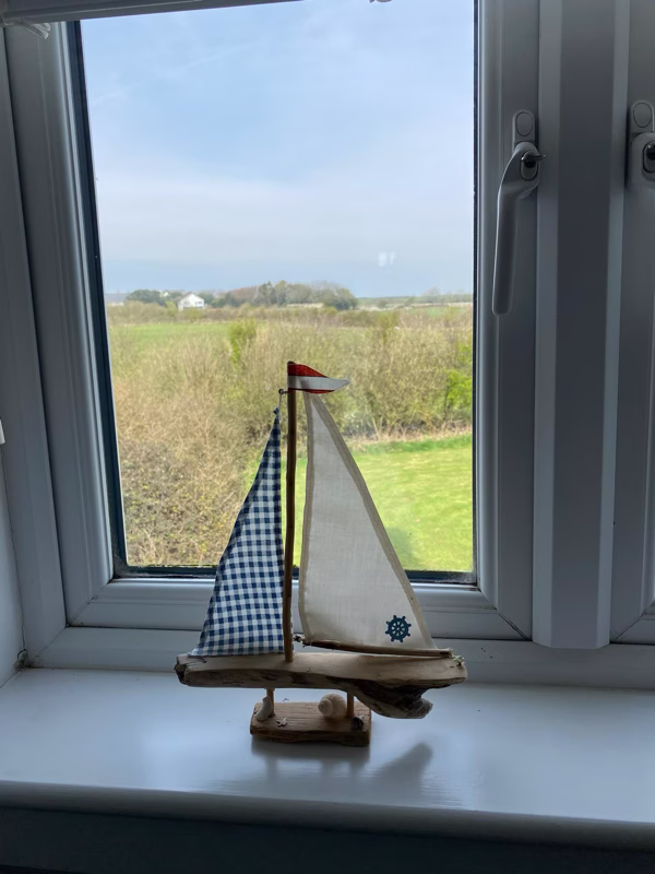 Sea Dream Lodge — toy sailboat on windowsill with sea view beyond