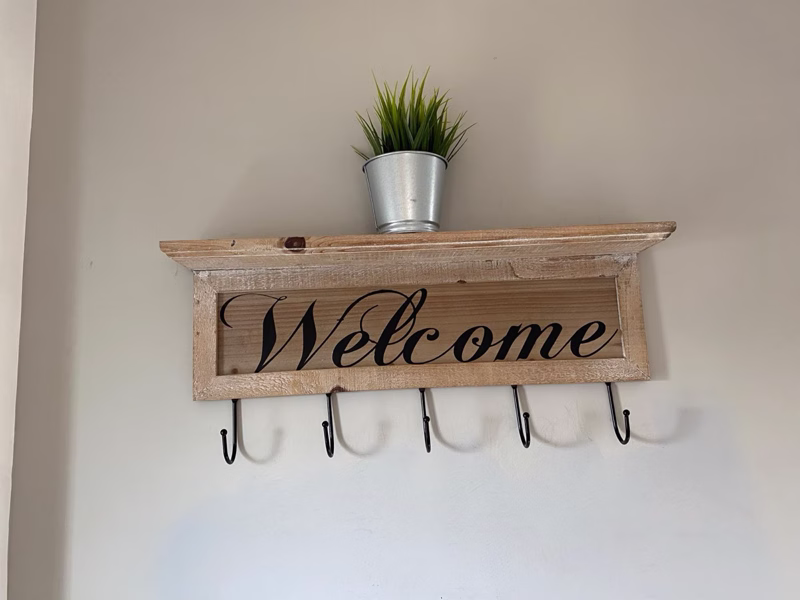 Sea Dream Lodge — rustic welcome sign with coat hooks