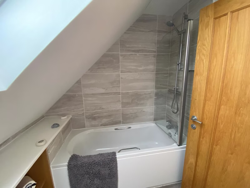 Sea Dream Lodge — bathroom with grey tiles and glass shower screen