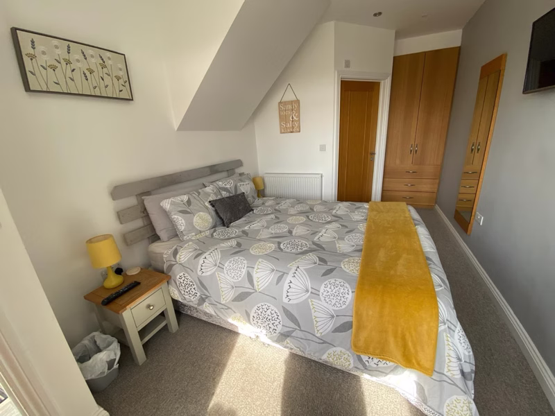 Sea Dream Lodge — double bedroom with yellow throw and oak wardrobe
