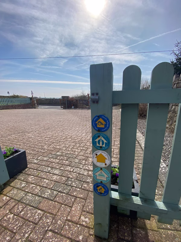 Sea Dream Lodge — teal garden gate with self-check-in lock box