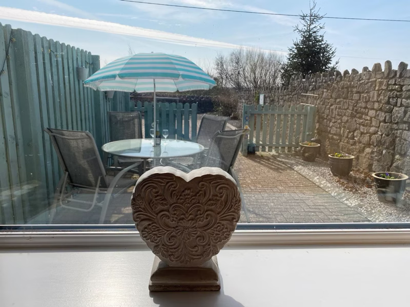 Sea Dream Lodge — window with heart ornament overlooking the garden